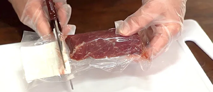 馬肉をボールから取り出し、真空パックを開封します。